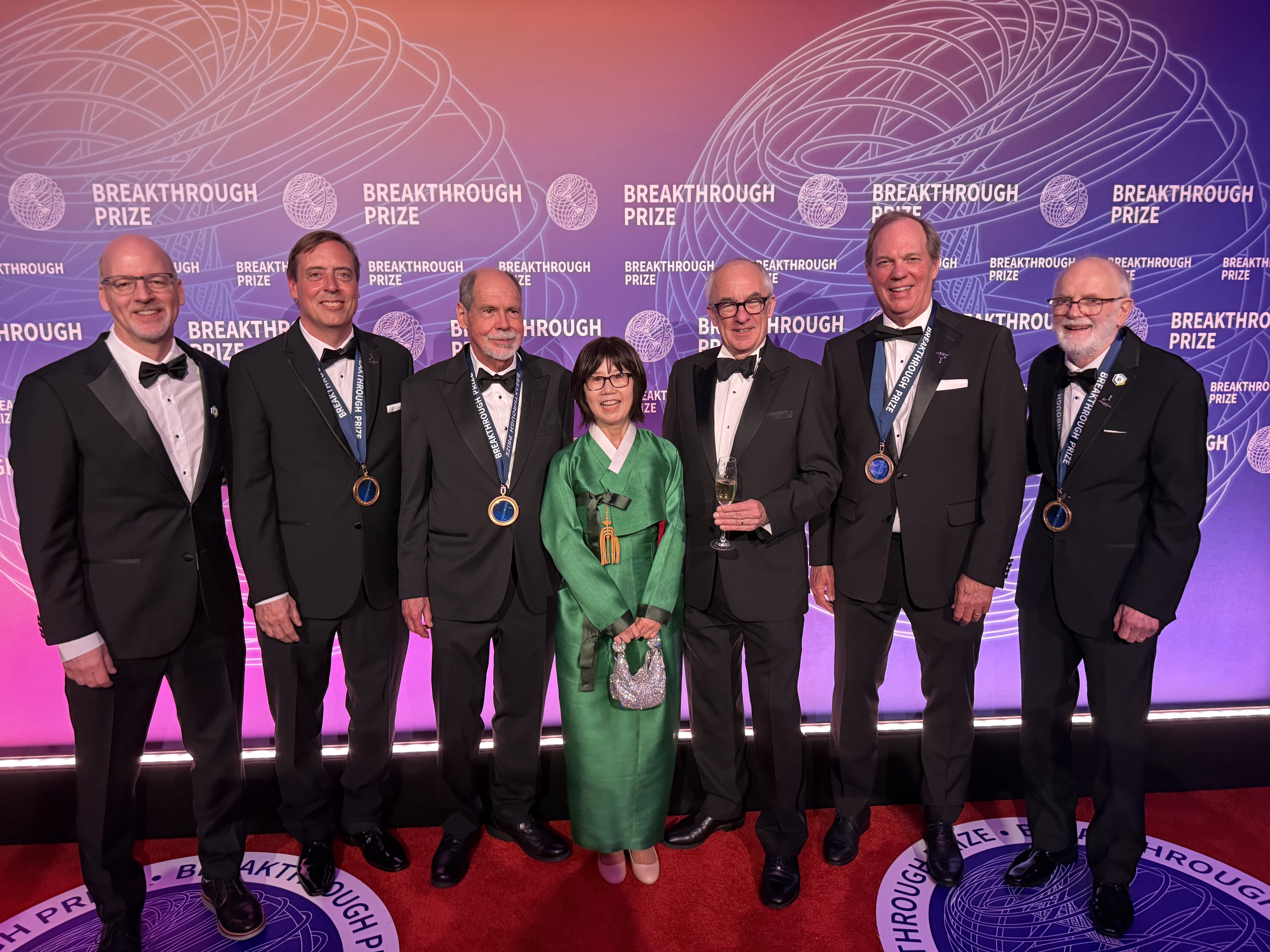 At the Breakthrough Prize ceremony on April 18, 2026, left to right: Brookhaven National Laboratory Interim Director John Hill, Fermi National Accelerator Laboratory (Fermilab) physicist Chris Polly, Boston University physicist Lee Roberts, Fermilab Director Emeritus Young-Kee Kim, CERN Director General Mark Thomson, University of Washington physicist David Hertzog, and Brookhaven Lab physicist William Morse. (Courtesy of Kat Morse)